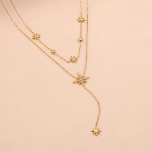 Detail of gold double-layered Y-shaped necklace with star pendants and sparkling zircons