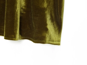 Detail view of olive green velvet fabric showing smooth texture and light-reflecting sheen