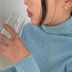 Minimalist gold pearl ring and irregular spherical earrings shown on a model