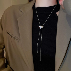 Detail of silver triangle pendant with shimmering rhinestones on a sleek snake chain