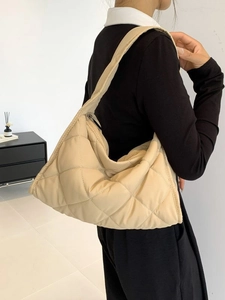 Quilted beige nylon shoulder bag with cloud texture shown in a professional model shot