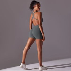 Detail of cross-back straps and open back design on a dark blue athletic romper