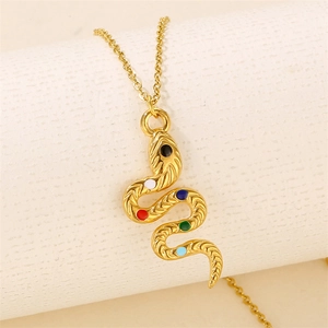 Gold stainless steel snake pendant necklace with colorful stones on textured background