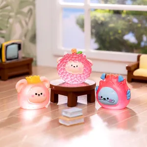 Glow-in-the-dark resin fruit animal miniatures set on a mini desk with soft lighting
