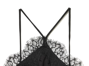 Detail view of intricate black lace mesh with delicate cross strap design and soft edges