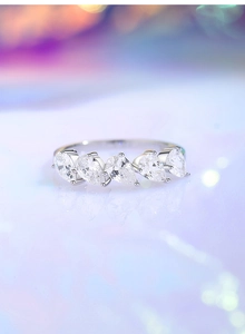 Close-up of five pear-cut cubic zirconia stones set in a polished silver ring band