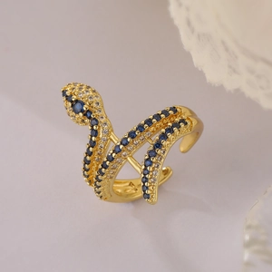 Close-up of gold snake ring with sparkling blue and clear zircon stones in macro view