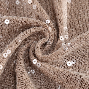 Gros plan détaillé du tissu en maille à paillettes champagne doré aux plis élégants