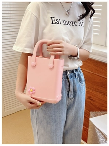 Detailaufnahme der rosa EVA Strandtasche mit süßem Blumenanhänger und wasserfester Textur