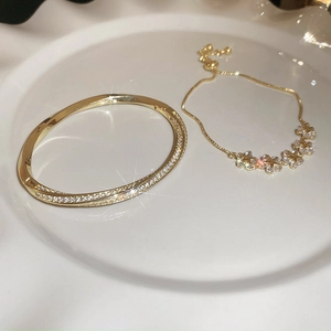 Detail of gold-plated star flower zircon bracelet set on white ceramic tray