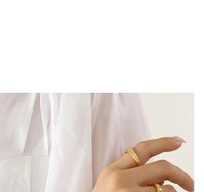 Close-up of elegant gold-plated rings on model hand with soft light and fabric