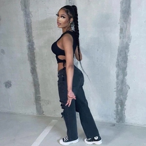 Détail d'un haut court ajouré noir et d'un jean déchiré de style streetwear