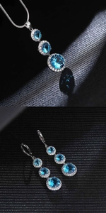 Close-up of blue teardrop zircon pendant necklace and drop earrings jewelry set
