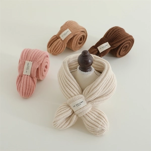 Close-up of soft knitted baby scarves in assorted colors with cross-over design