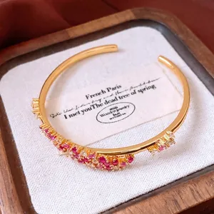 Bracelet jonc vague vintage plaqué or 18 carats avec zircons rouges et blancs sur bois
