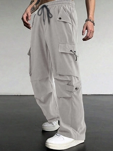 Detail view of light grey cargo pants featuring functional pockets and drawstring waist