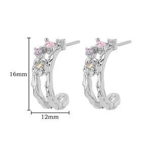 Detailed view of silver wave earrings with floral patterns and colorful gemstones