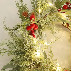 Christmas wreath with LED lights, red berries, and frosted pine branches for holiday decor