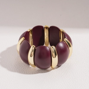 Detail of burgundy acrylic geometric links and gold metal spacers on a minimalist bracelet