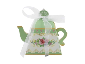 Close-up of teapot-shaped candy box with floral patterns and a white organza ribbon