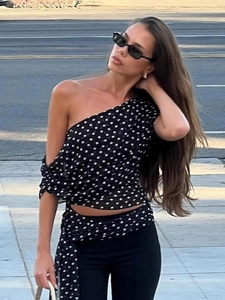 Haut asymétrique à pois avec une épaule dénudée et une coupe moderne en mousseline