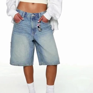 Detail der blauen Denim-Jorts mit Stern-Accessoires am Bund und Metallknöpfen