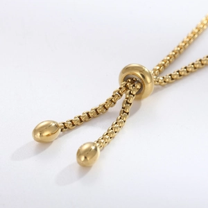 Detailed macro view of the golden adjustable box chain slider clasp for heart bracelets