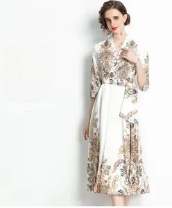 Detalle de vestido blanco con estampado paisley, escote en V y cinturón de tela