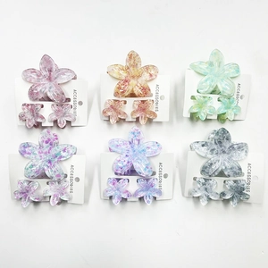 Detailed set of 3 plumeria flower hair claws in six vibrant colors on display cards