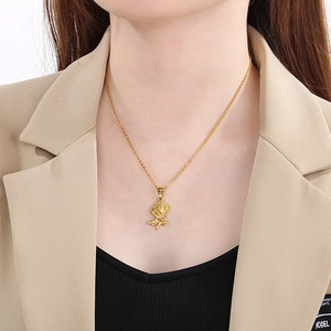 Gros plan d'un collier pendentif rose dorée avec sculpture 3D sur un mannequin femme