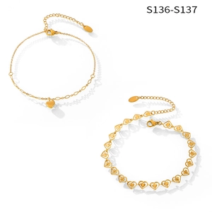 Detail of gold-plated heart-shaped anklets with textured heart charms and lobster clasp