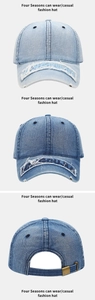 Dettaglio cappello in denim lavato con ricami, cuciture e fibbia in metallo regolabile