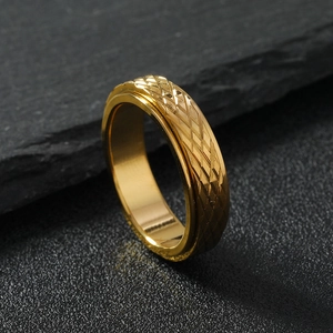 6mm gold rotatable fidget ring with diamond pattern mesh on a dark stone background