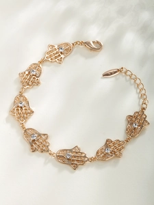 Détail d'un bracelet main de Hamsa doré avec pierres en zircon et chaîne de réglage