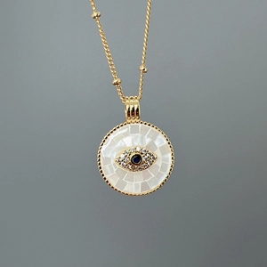 Golden necklace with a shell mother-of-pearl evil eye pendant and sparkling blue zircon