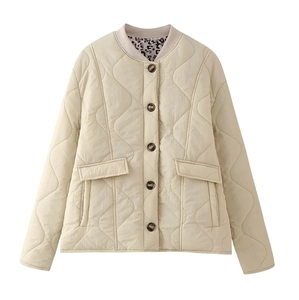 Detail of beige quilted jacket featuring leopard print lining and brown buttons