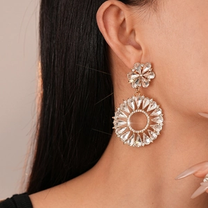 Close-up of luxury flower hoop earrings with glittering rhinestones on a female model