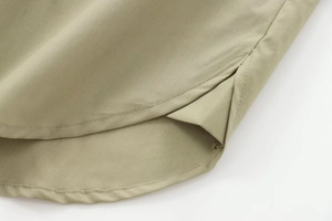 Detail view of khaki poplin shirt side slit with high-density stitching and premium finish