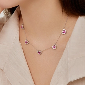 Close-up of S925 silver necklace with five pink heart pendants and white crystals