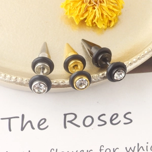 Detailed shot of bullet spike ear studs in silver, gold and black with crystals