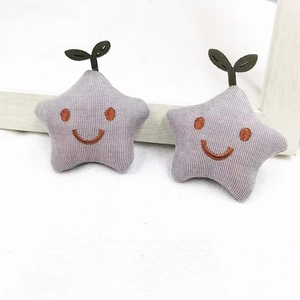 Detail of light purple star-shaped plush pins with cute embroidery and cotton texture