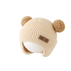 Cozy cream ribbed knit baby winter hat with brown bear ear pom-poms and ear protection