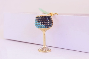 Detailed close-up of a gold alloy wine glass keychain with gradient blue rhinestones