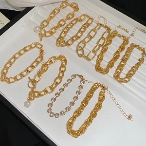 Chic 4-piece gold chain bracelet set with pearls and rhinestones on a white display