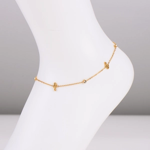 Golden musical note anklet with clear crystal charms on model's ankle against white background