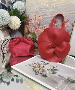 Detail view of red petal-shaped tote bag with matching drawstring inner pouch and beads
