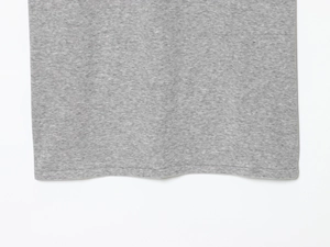 Detailed close-up of gray knitted fabric texture and double-needle stitched hem of the skirt