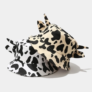 Detail of cow print bucket hats in white and beige with cute 3D horns and wide brim