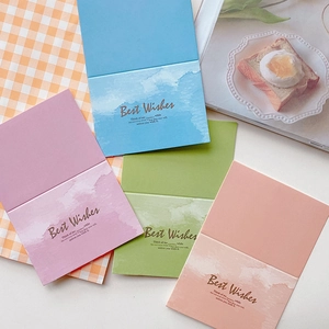 Flat lay of colorful minimalist greeting cards with Best Wishes text on a grid tablecloth
