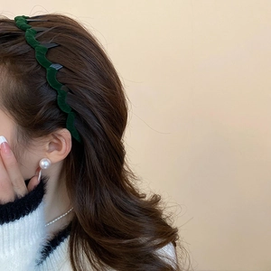 Detail of dark green velvet wavy headband worn on wavy hair with anti-slip inner teeth